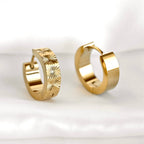 Front and rear views of gold sunburst hoops on a white surface, showing the patterned band and polished back.