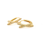 Gold-tone criss cross huggie hoop earrings with two rows of clear stones forming an X at the front, on a white background.