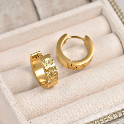 Gold sunburst hoop earrings in a cream jewellery case, showing the textured exterior and hinged closures.