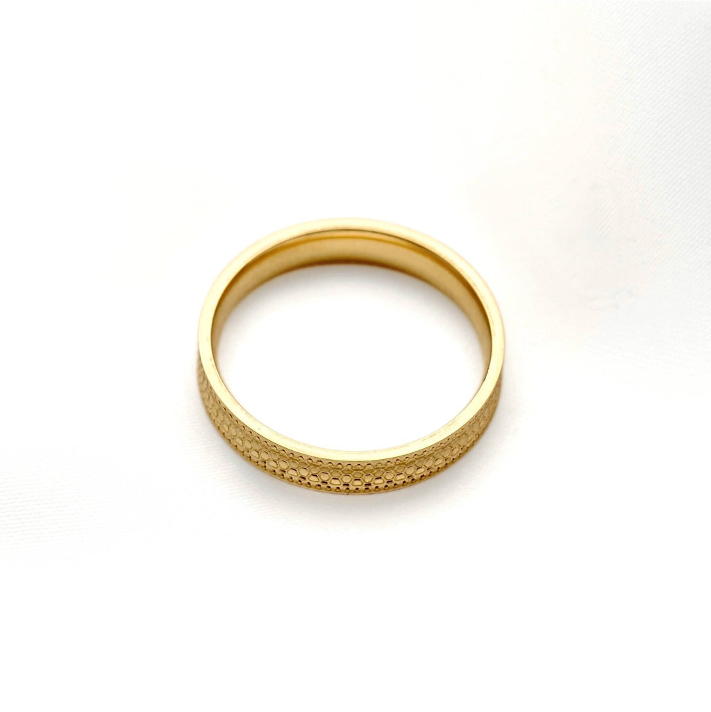 Gold stacking ring lying flat on a white background, showing its circular shape and smooth interior.