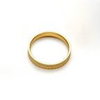 Gold stacking ring lying flat on a white background, showing its circular shape and smooth interior.